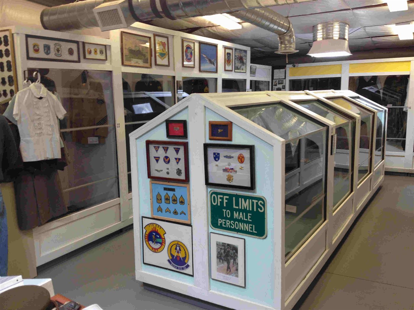 Museum display case with framed military patches and medals